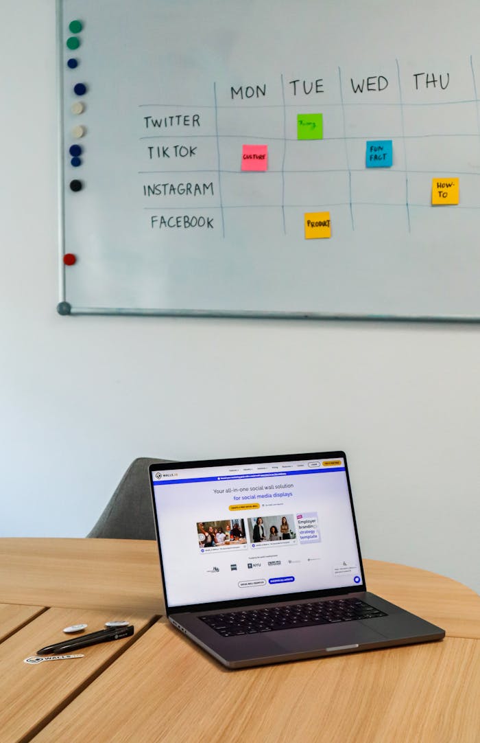 why-choose-us A modern office setup featuring a laptop and a whiteboard schedule for social media platforms.
